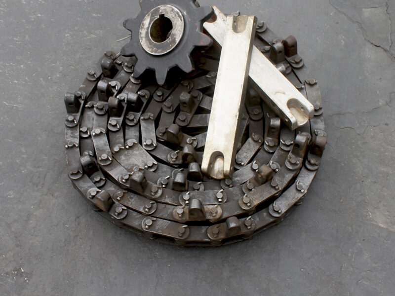 close up of a chain, sprocket and feeder bars
