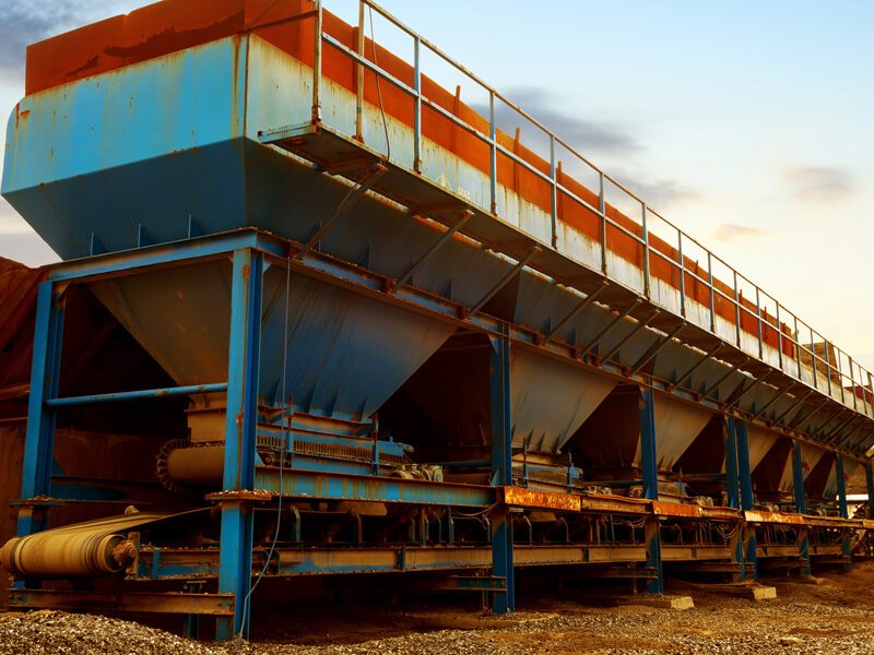A hopper above a conveyer belt