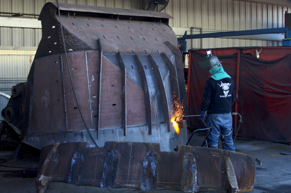 Man welding a large metal piece.